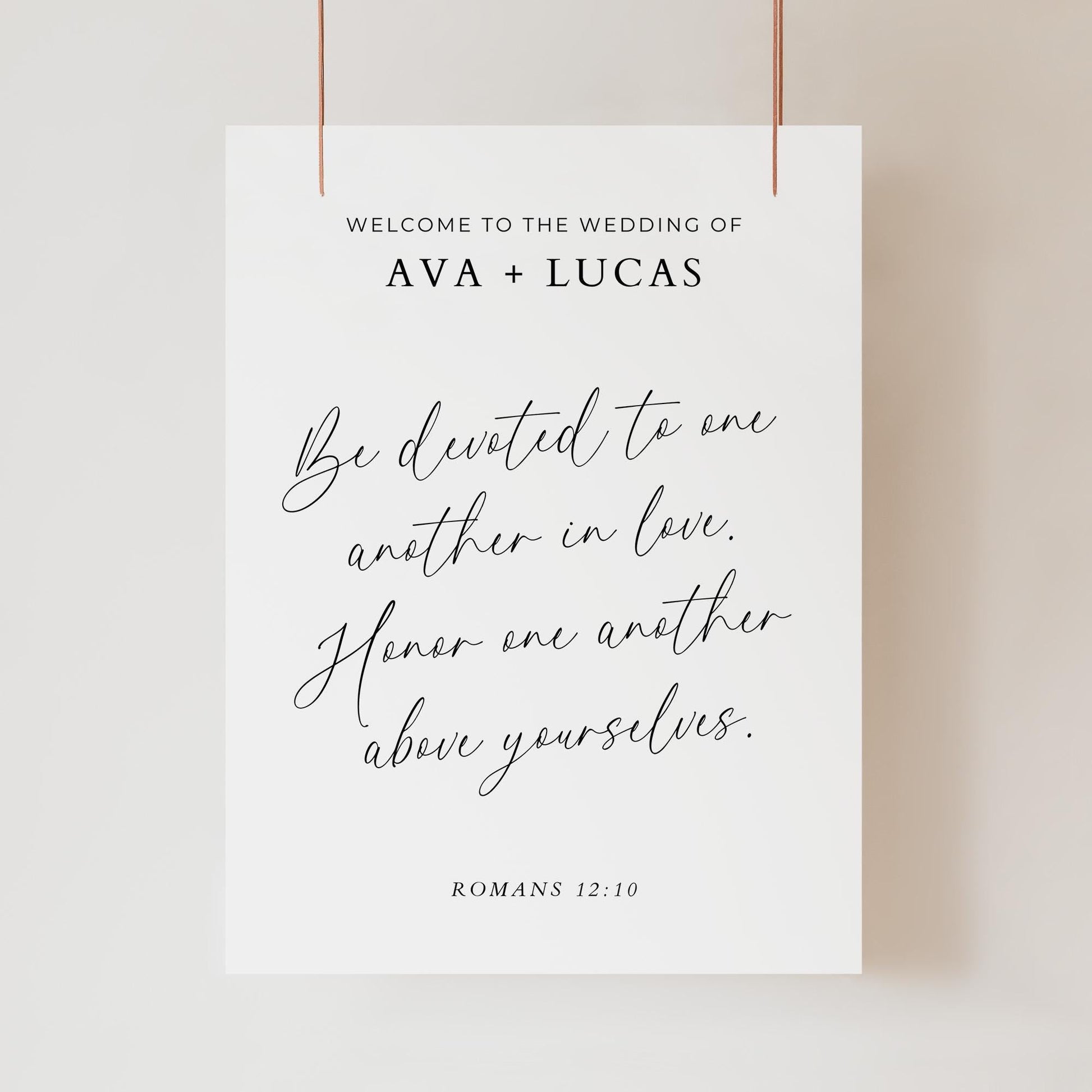 A wedding welcome sign in a minimalist style with the words &#39;Welcome To The Wedding Of Ava + Lucas&quot; and then the scripture in script font of &quot;Be devoted to one another in love. Homor one another above yourselves&#39;. Romans 12:10