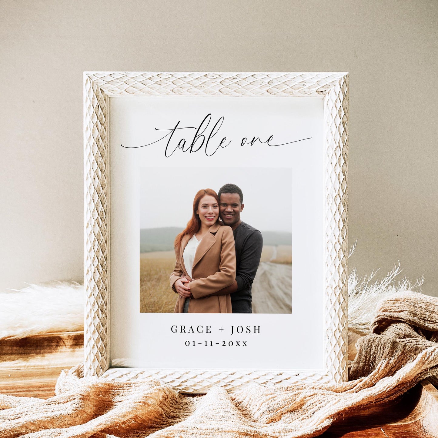 Table number card featuring the text &#39;table one&#39; in an elegant calligraphy script font, followed by a large photo of a couple, then their names and wedding date.